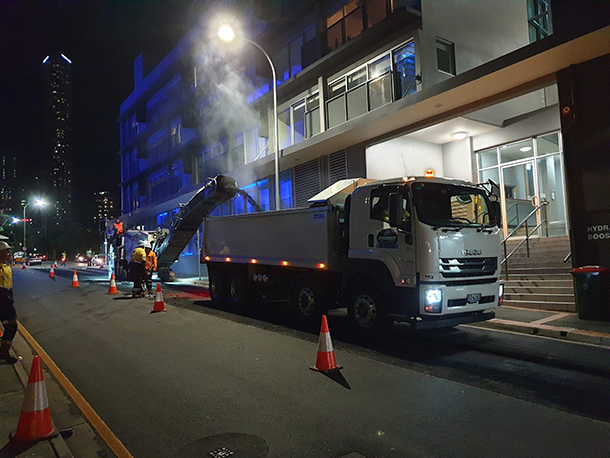 A truck laying bitumen for commercial roadwork at night